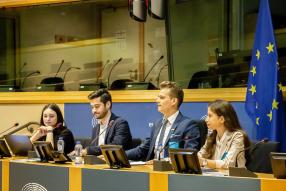 Young people sitting next to the EU flag